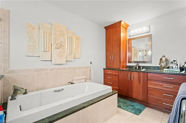 a bathroom with a tub sink and mirror