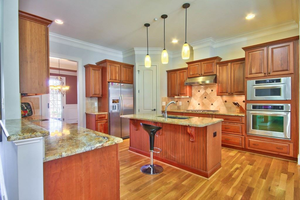 3417 Ebenezer Church Road Raleigh, NC 27612 - Photo 7 of 25 GOURMET KITCHEN with all the upgrades! Granite counter tops, a large island with prep sink, pantry, wine fridge, ss appliances and gas range! Kitchen