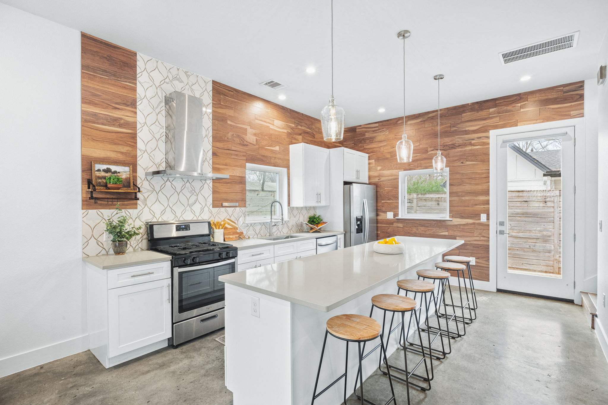 1218 Eleanor Street, Unit 1 Austin, TX 78721 - Photo 9 of 39 a kitchen with stainless steel appliances kitchen island granite countertop a stove a sink and a refrigerator