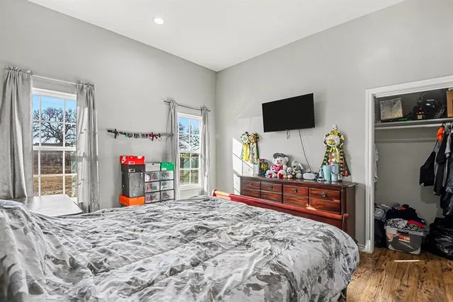 a bedroom with a bed and a flat tv screen on dresser