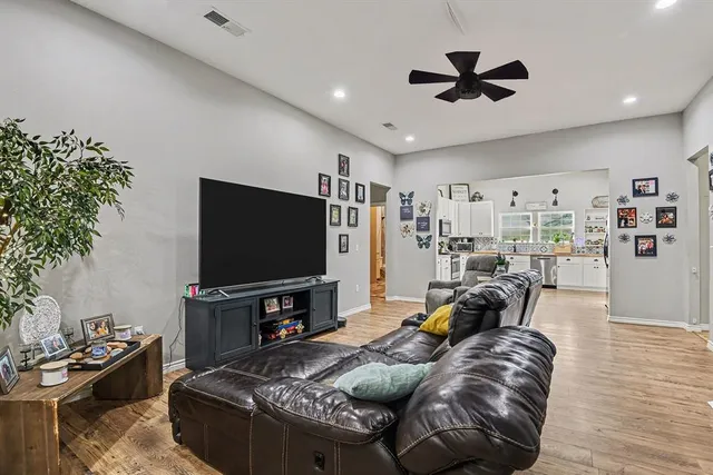 a living room with furniture and a flat screen tv with wooden floor
