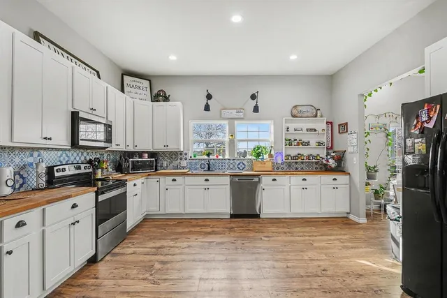 a kitchen with granite countertop white cabinets and stainless steel appliances