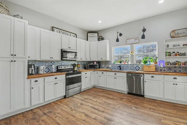 a kitchen with granite countertop white cabinets and white appliances