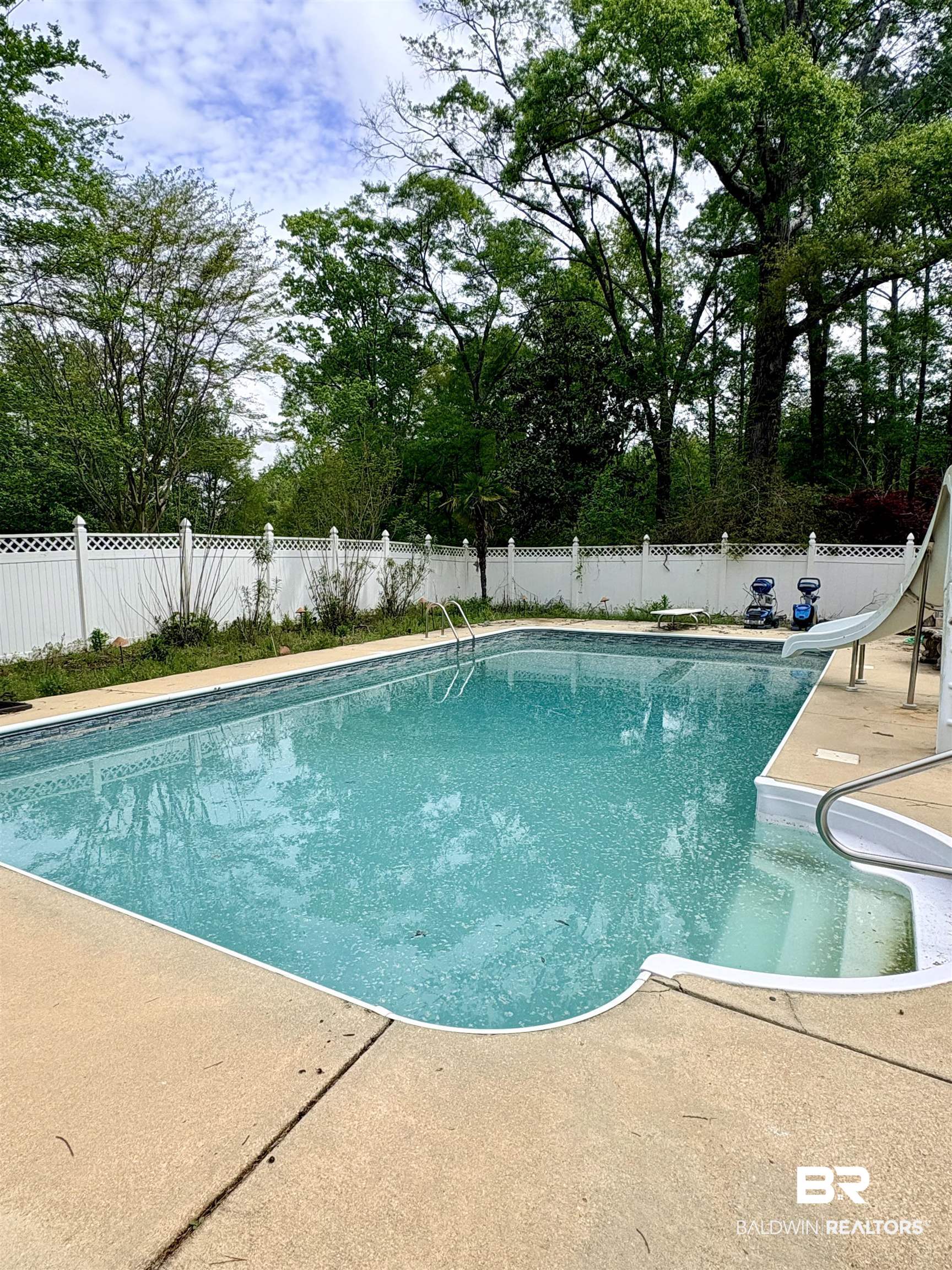 1018 Bates Road Evergreen, AL 36401 - Photo 20 of 21 View of swimming pool with a fenced backyard, a water slide, and patio surround