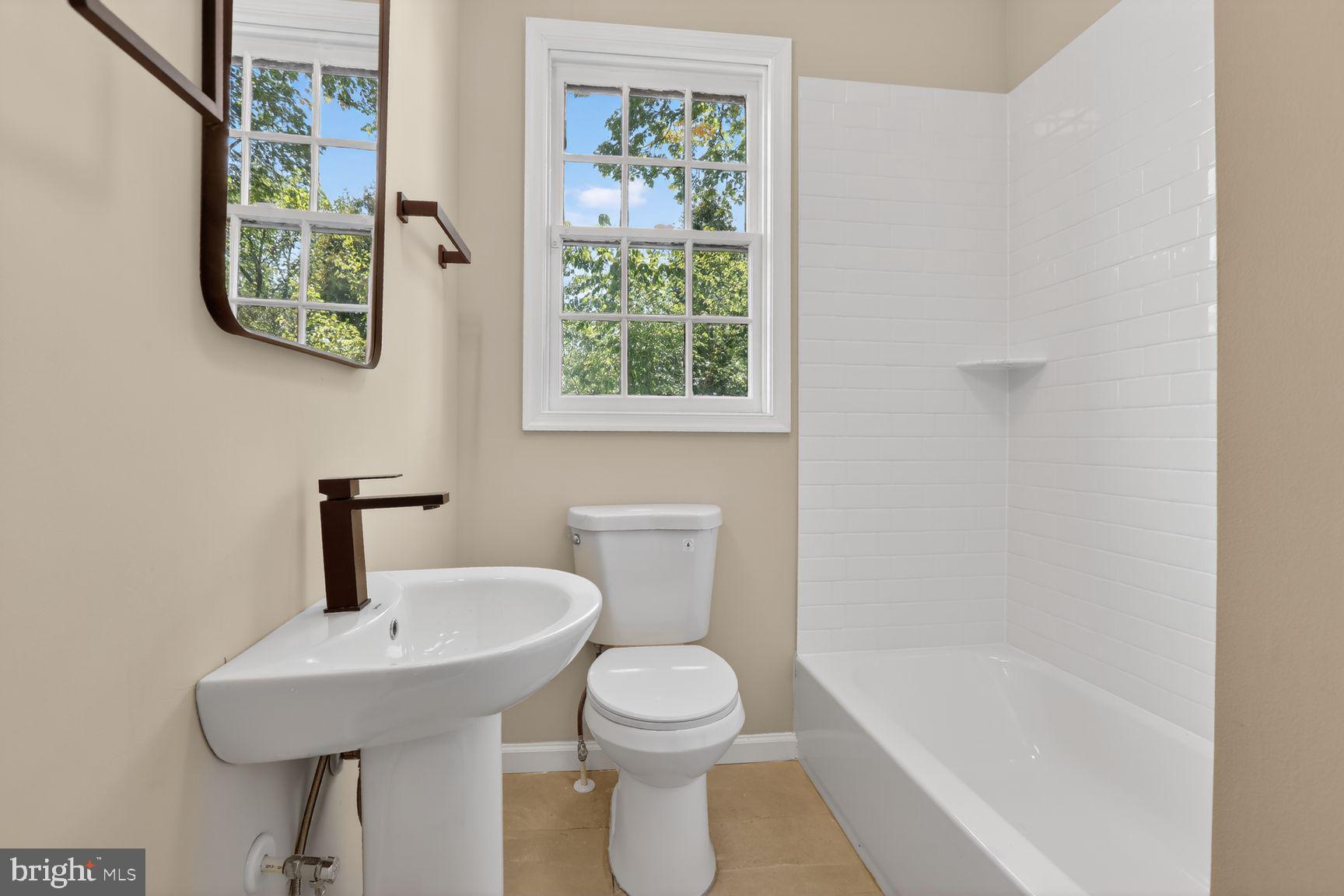 315 East Cold Spring Lane Baltimore, MD 21212 - Photo 6 of 25 a bathroom with a sink a toilet and a bathtub