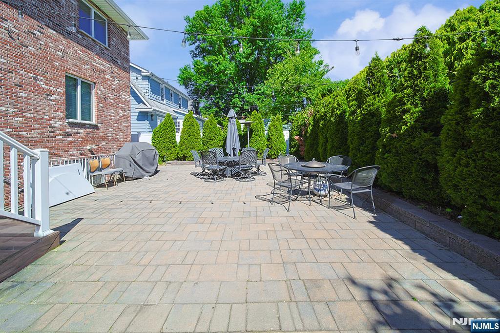 897 Virgil Avenue Ridgefield, NJ 07657 - Photo 7 of 50 a view of a patio with a table and chairs under an umbrella