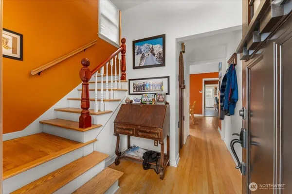a view of a hallway with wooden floor and staircase
