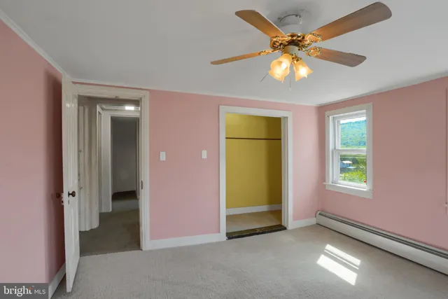 an empty room with fan and windows
