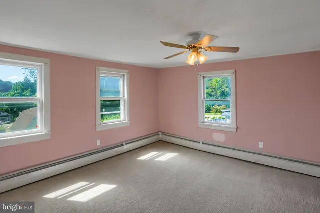 a view of a livingroom with a ceiling fan and window