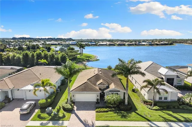 an aerial view of residential houses with outdoor space and ocean view