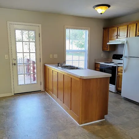 a kitchen with stainless steel appliances granite countertop a stove a sink a refrigerator and a microwave