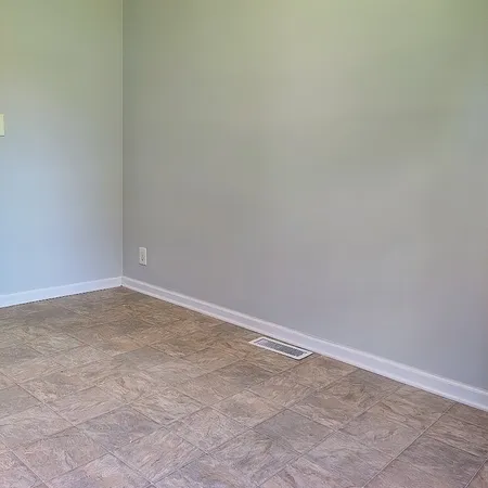an empty room with windows and chandelier fan