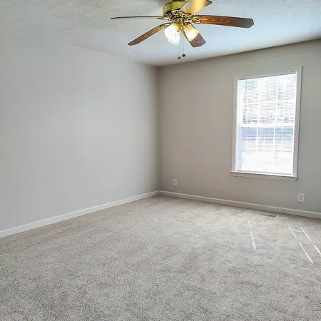 an empty room with a chandelier fan