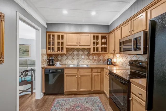 a kitchen with granite countertop a refrigerator stove and microwave