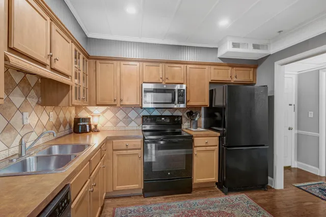 a kitchen with stainless steel appliances granite countertop a refrigerator and a stove top oven