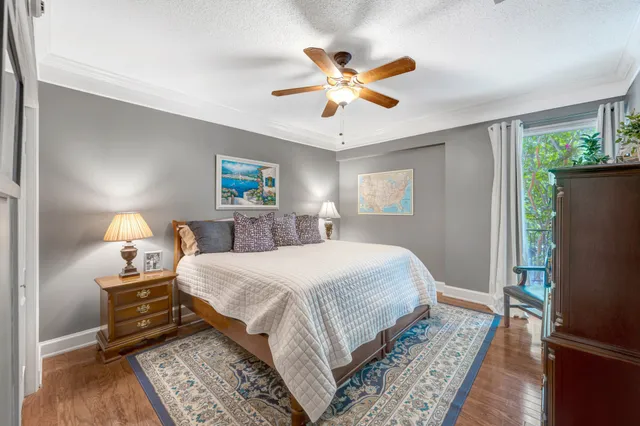a bedroom with a bed dresser and a potted plant