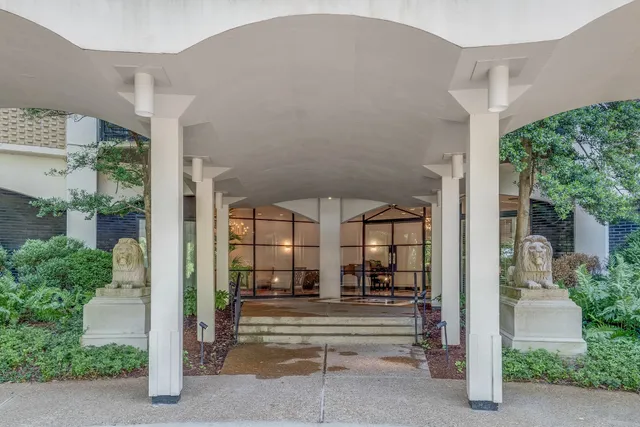 a living room with a black white checkered floor with couches and chandelier