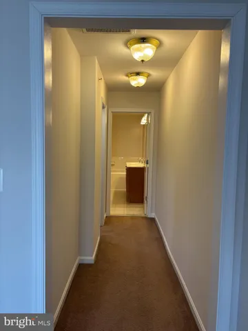 a view of a hallway with wooden floor and a large window