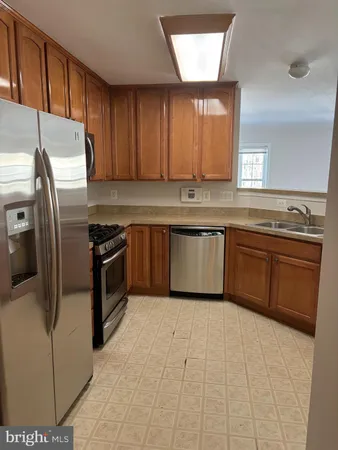a kitchen with stainless steel appliances granite countertop a stove a sink dishwasher and a refrigerator