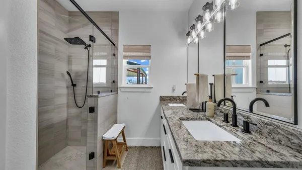 a bathroom with double vanity sink and mirror