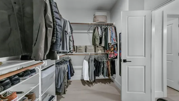 a view of walk in closet with clothes