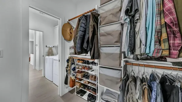 a view of walk in closet with clothes and shoes