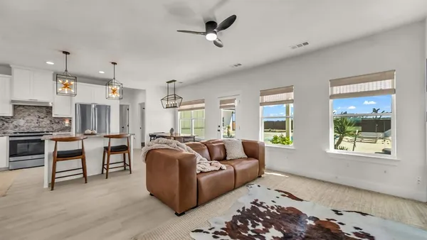 a living room with furniture a flat screen tv and window