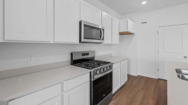 a kitchen with white cabinets and stainless steel appliances