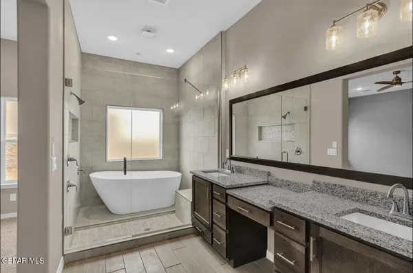 a spacious bathroom with a granite countertop sink mirror and bathtub