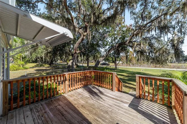 a living room with furniture a chandelier and wooden floor