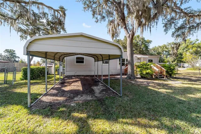 a view of backyard with outdoor seating and plants