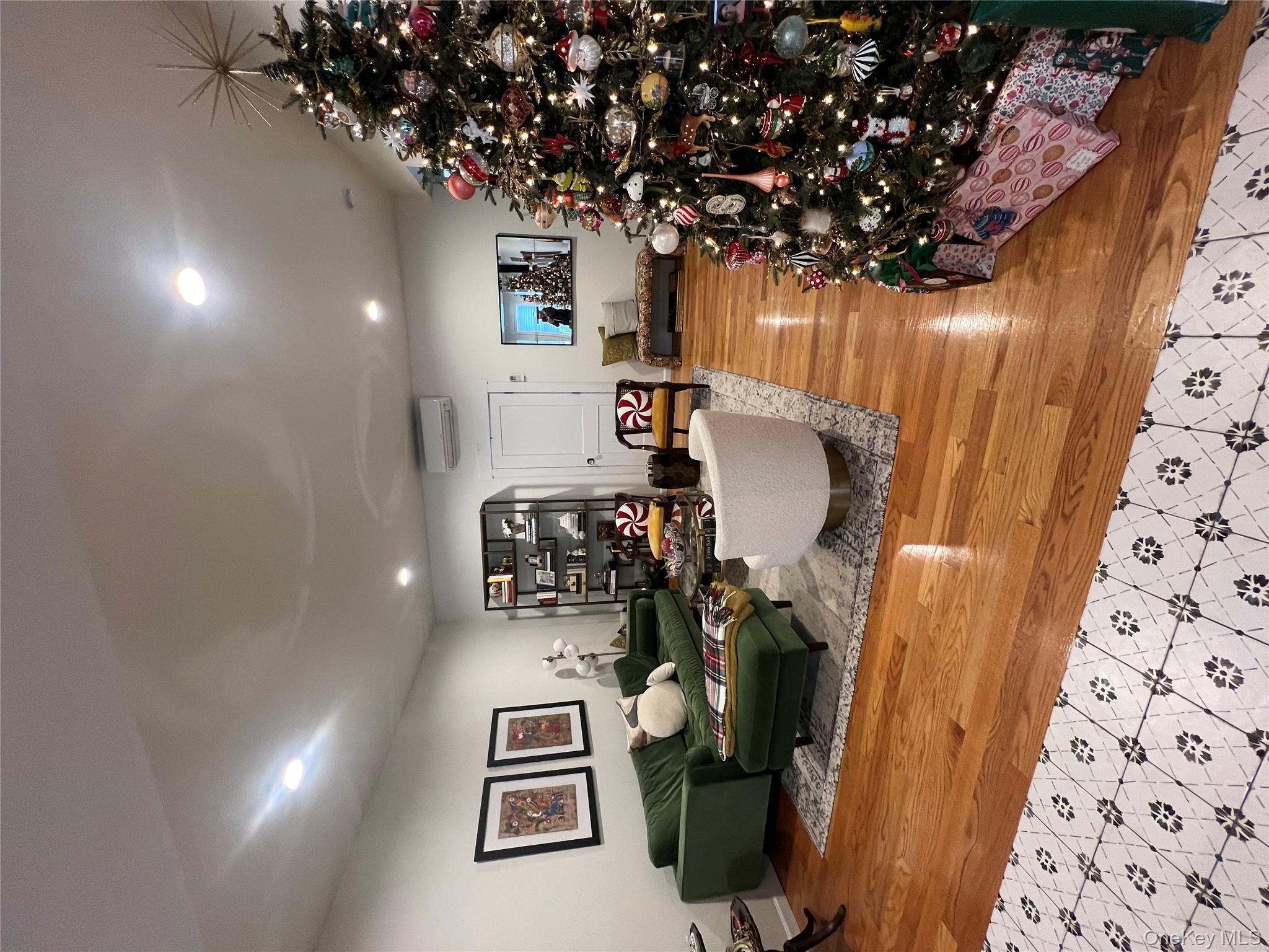 103 Filors Lane, Unit 101 Stony Point, NY 10980 - Photo 6 of 23 a living room with furniture hard wood floor and a chandelier