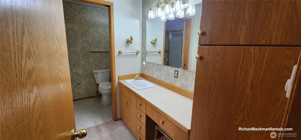 a spacious bathroom with a granite countertop sink and a mirror