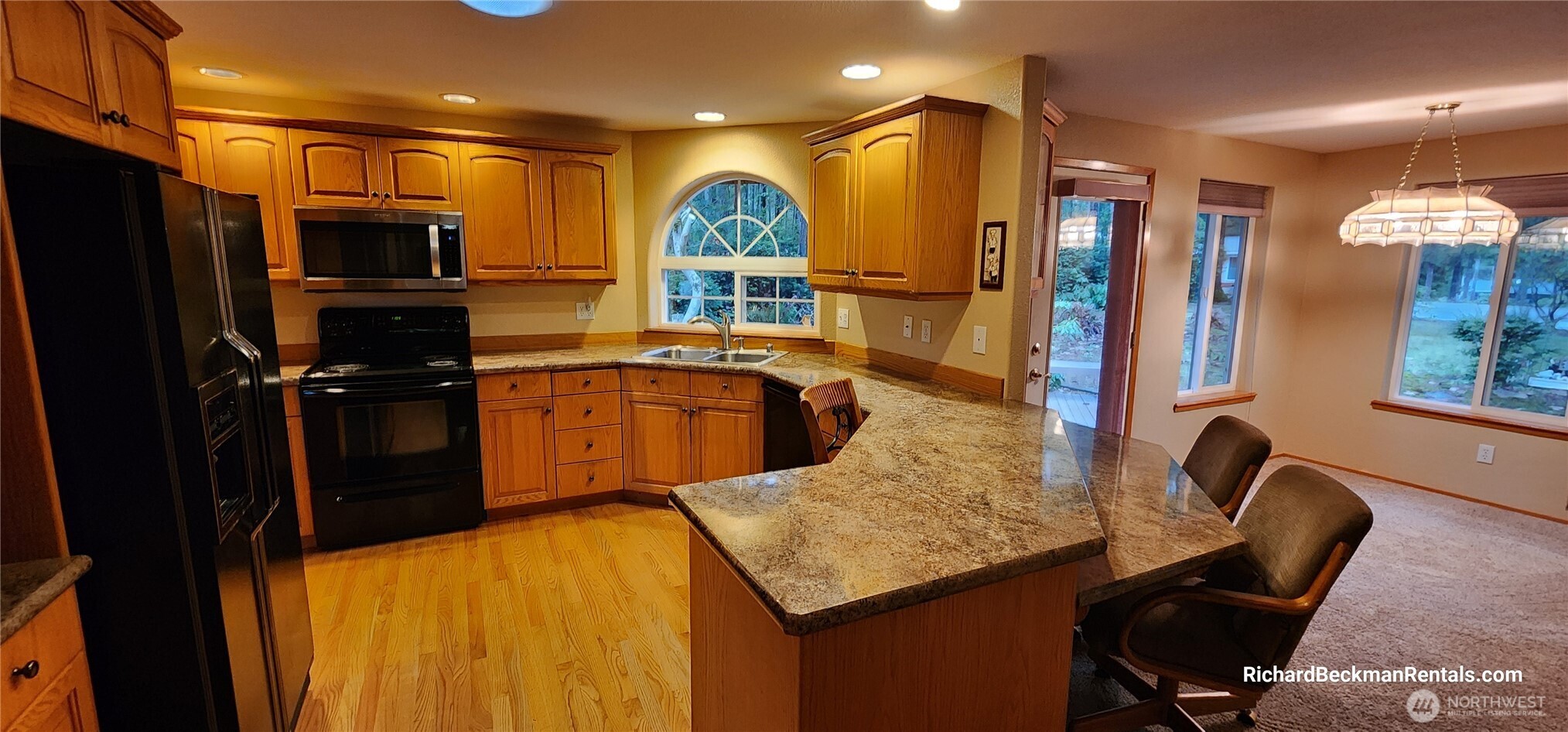 701 East Rd Of Tralee Shelton, WA 98584 - Photo 4 of 20 a kitchen with a table chairs refrigerator and microwave
