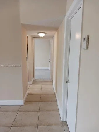 a view of a hallway with closet and a bathroom