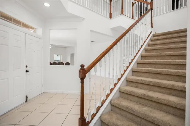 a view of staircase with white walls and railing