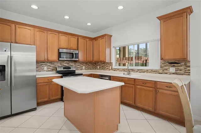 a kitchen with stainless steel appliances granite countertop a sink counter space cabinets and a refrigerator