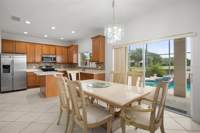 a kitchen with granite countertop a refrigerator stove top oven and cabinets