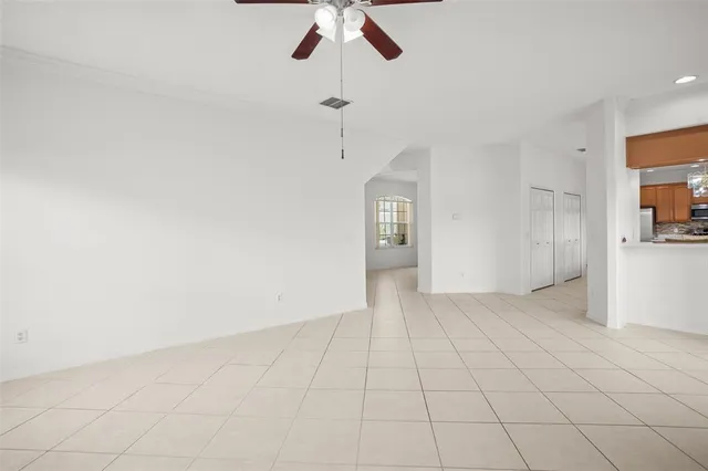 an empty room with fan and windows