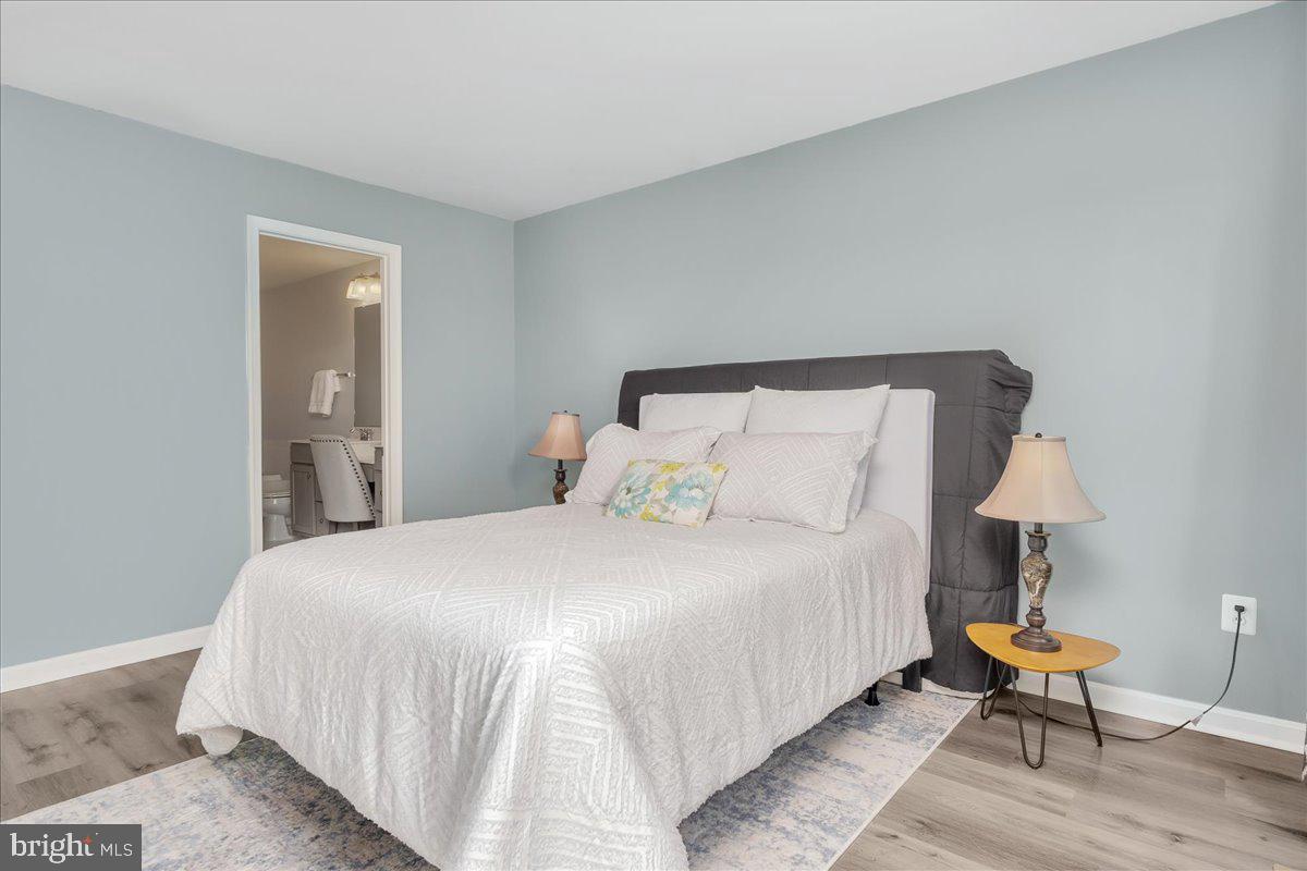 1874 Monocacy View Circle, Unit 28B Frederick, MD 21701 - Photo 15 of 35 a bedroom with a bed and a lamp on table