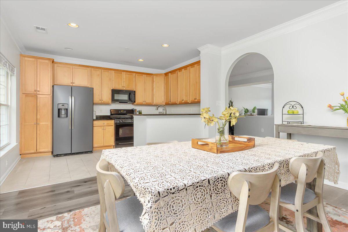 1874 Monocacy View Circle, Unit 28B Frederick, MD 21701 - Photo 9 of 35 a kitchen with stainless steel appliances granite countertop a table chairs and a refrigerator