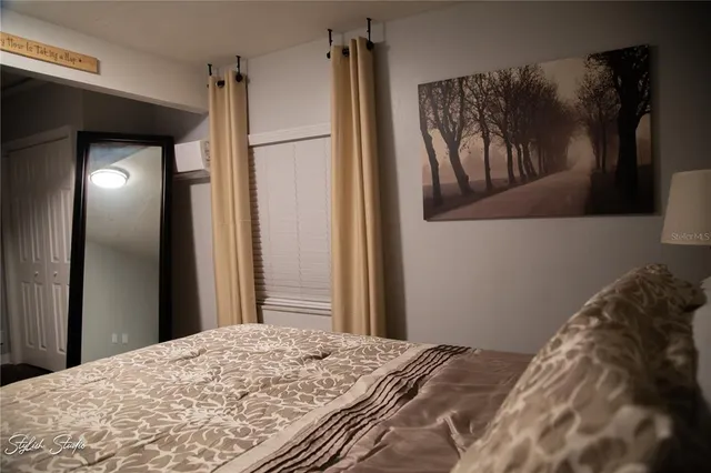 a bedroom with a bed and a painting on the wall