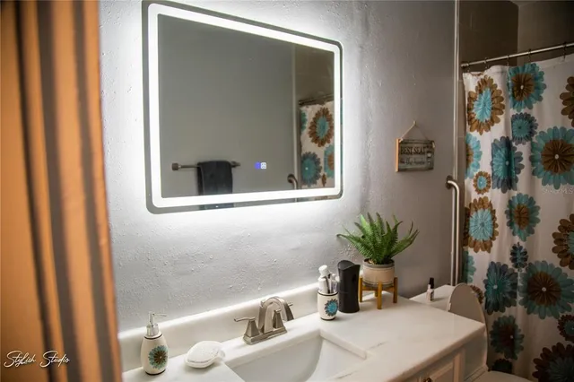 a bath room with a sink and a mirror