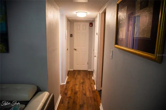 a view of a hallway with wooden floor