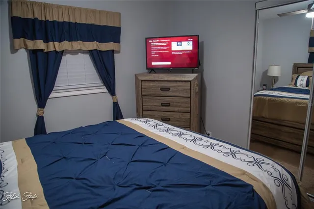 a bedroom with a bed and a television