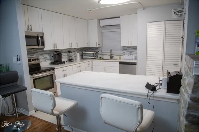 a kitchen with white cabinets and appliances