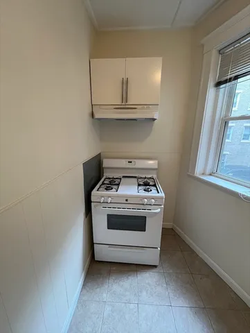 a white stove top oven sitting inside of a kitchen