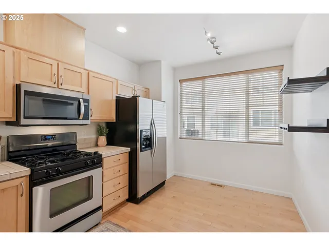 a kitchen with granite countertop a refrigerator stove and microwave
