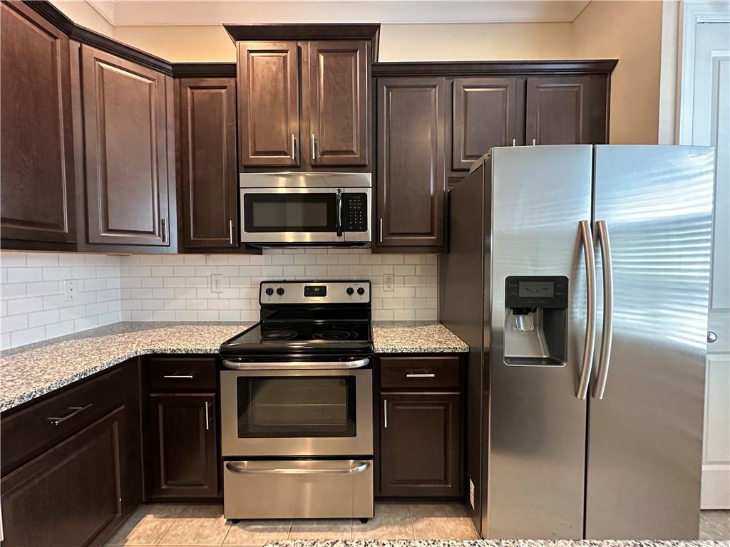 2417 Tenor Lane Alpharetta, GA 30009 - Photo 11 of 43 a kitchen with granite countertop a refrigerator and a stove top oven