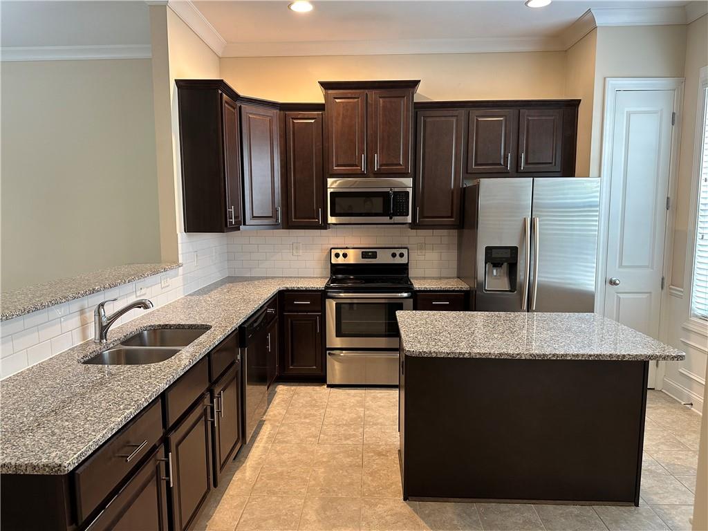 2417 Tenor Lane Alpharetta, GA 30009 - Photo 10 of 43 a kitchen with kitchen island granite countertop a sink stove and refrigerator